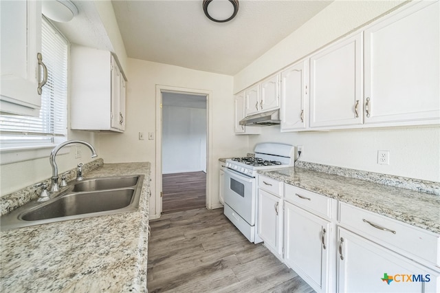 kitchen featuring white cabinetry, sink, light stone counters, light hardwood / wood-style flooring, and white range with gas stovetop