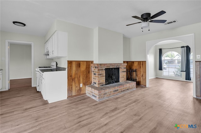 living room with a fireplace, light hardwood / wood-style flooring, and ceiling fan