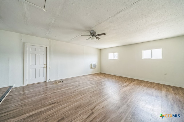 spare room with hardwood / wood-style flooring, ceiling fan, and a textured ceiling