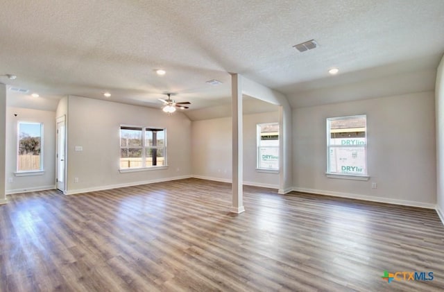 unfurnished living room featuring a textured ceiling, ceiling fan, dark wood-type flooring, and vaulted ceiling