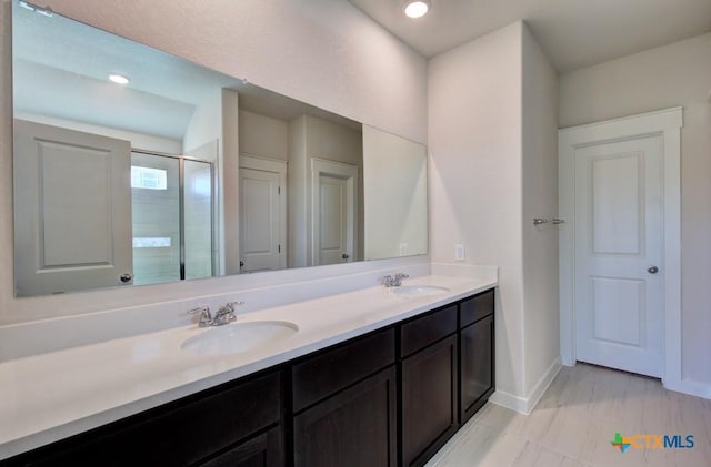 bathroom with a shower with door and vanity