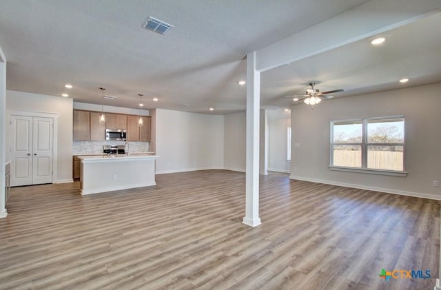 unfurnished living room with ceiling fan and light hardwood / wood-style floors