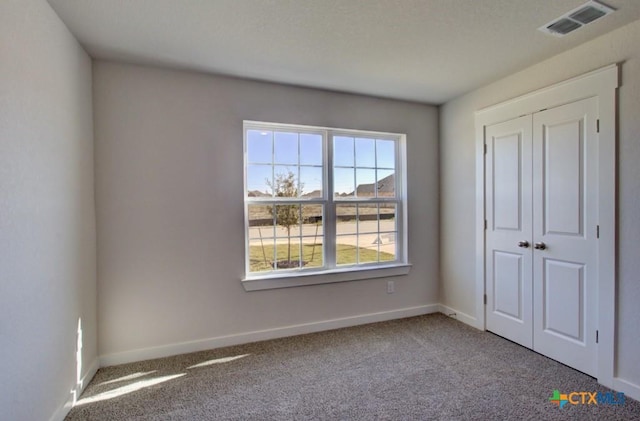 unfurnished bedroom featuring carpet flooring and a closet