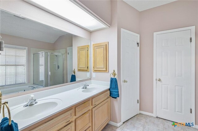 621 Brocton St, Victoria, TX 77904 - bathroom featuring a stall shower, double vanity, a garden tub, tile patterned flooring, and vaulted ceiling