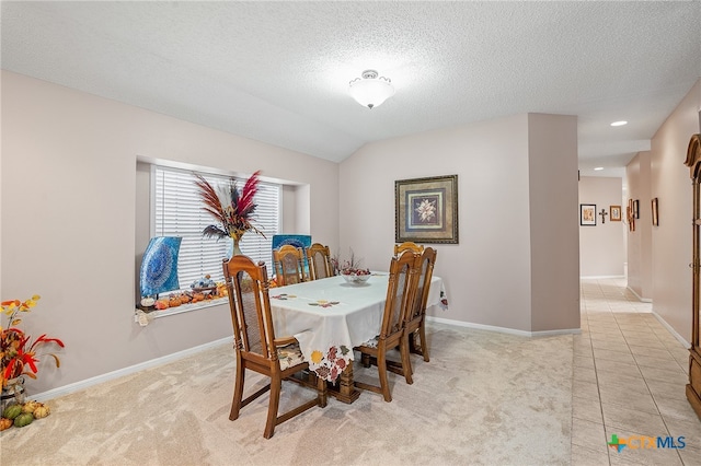 carpeted dining room featuring lofted ceiling and a textured ceiling