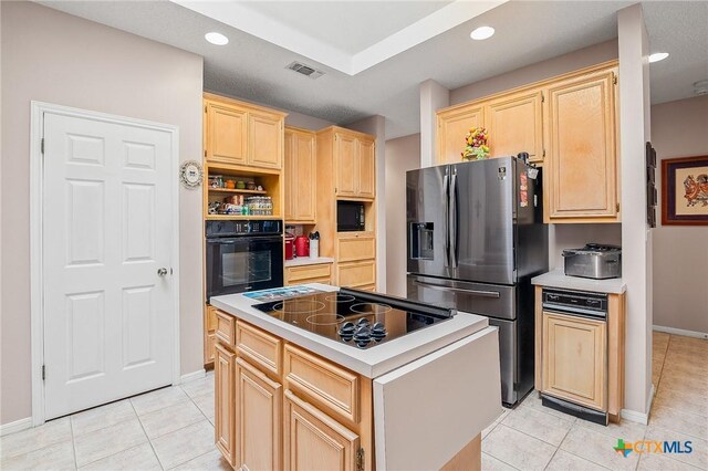 621 Brocton St, Victoria, TX 77904 - kitchen with black appliances, light brown cabinets, light tile patterned flooring, a kitchen island, and light countertops