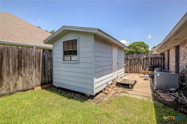 view of outdoor structure with a yard and central AC unit