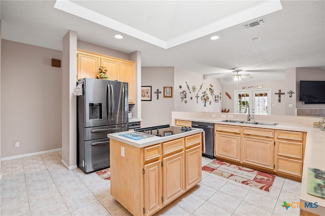 kitchen featuring a kitchen island, appliances with stainless steel finishes, light brown cabinets, sink, and ceiling fan