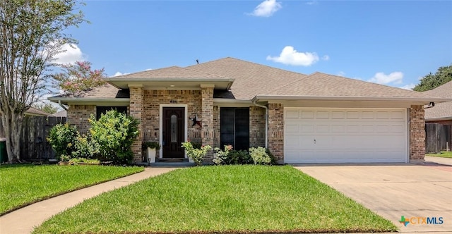 621 Brocton St, Victoria, TX 77904 - view of front of property featuring an attached garage, brick siding, concrete driveway, and a shingled roof