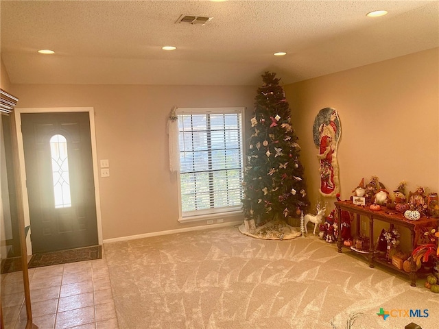 entryway with carpet flooring and a textured ceiling