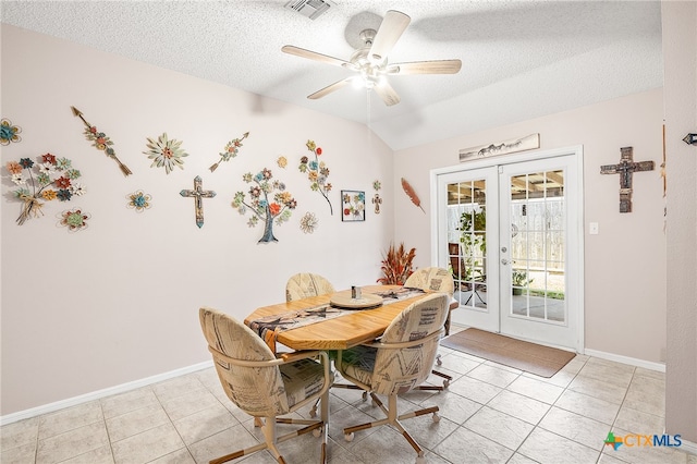 tiled dining space featuring a textured ceiling, french doors, and ceiling fan