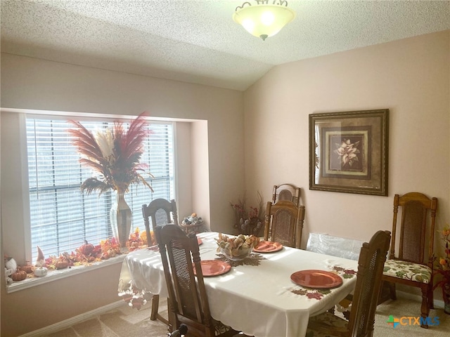 carpeted dining area with vaulted ceiling and a textured ceiling