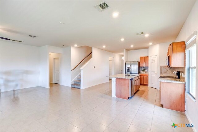 3802 Endicott Dr, Killeen, TX 76549 - kitchen featuring appliances with stainless steel finishes, a kitchen island with sink, open floor plan, backsplash, and recessed lighting
