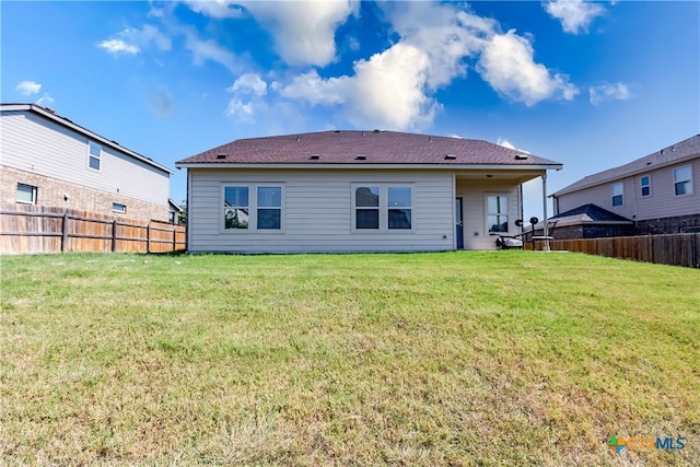 back of property featuring a yard