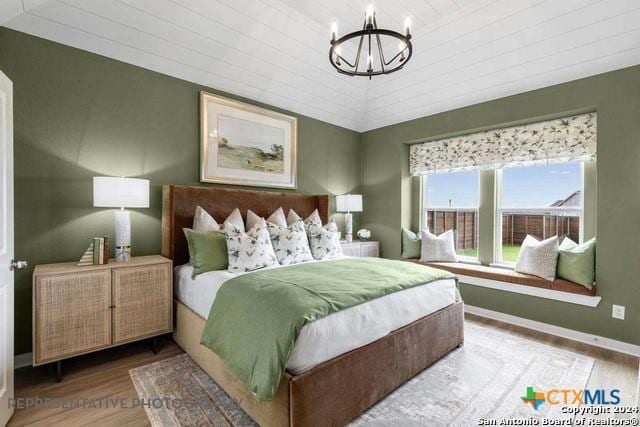 bedroom with a chandelier, wood-type flooring, and wooden ceiling