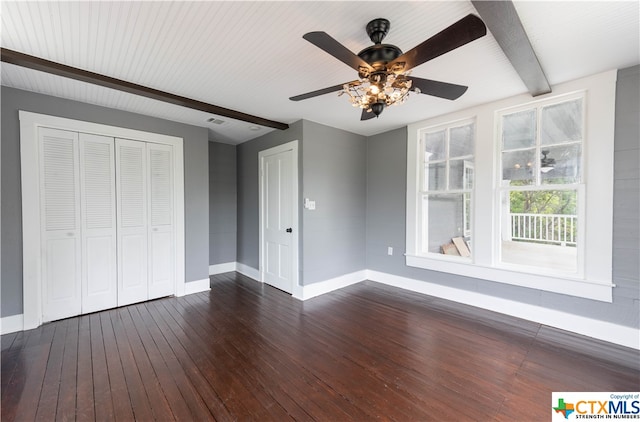 unfurnished bedroom featuring dark wood-type flooring, ceiling fan, beam ceiling, and a closet