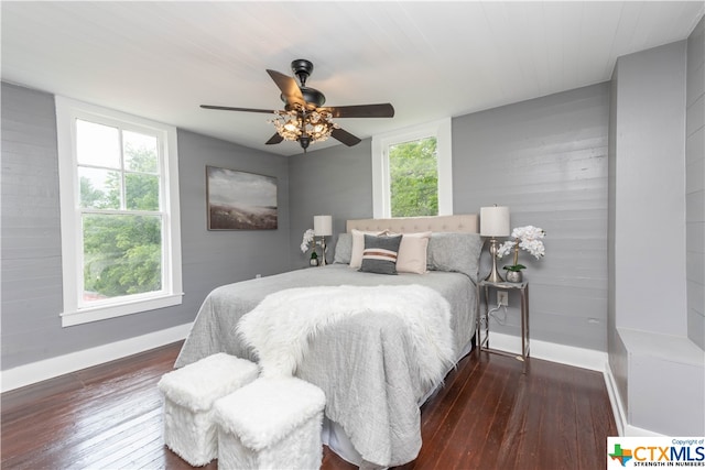 bedroom featuring dark wood-type flooring, ceiling fan, and multiple windows