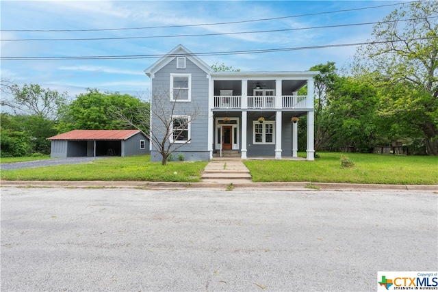 view of front of home with a front lawn, a balcony, and covered porch