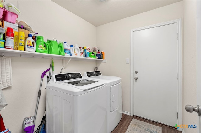 clothes washing area with dark wood-type flooring and washer and clothes dryer