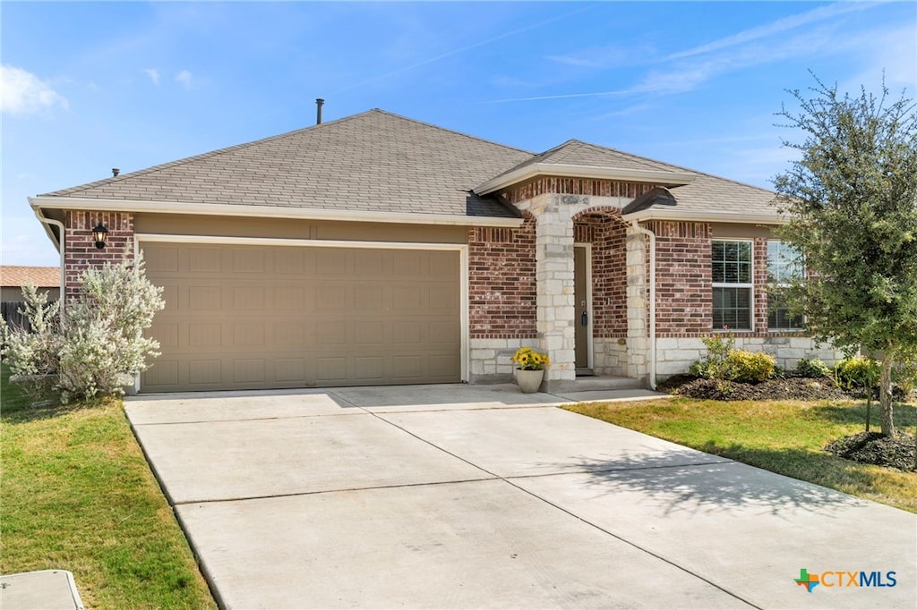 ranch-style house with a garage and a front yard