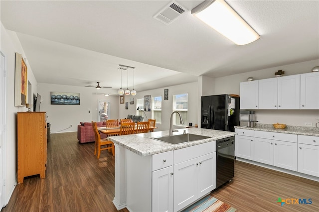 kitchen with white cabinets, black appliances, sink, a kitchen island with sink, and decorative light fixtures