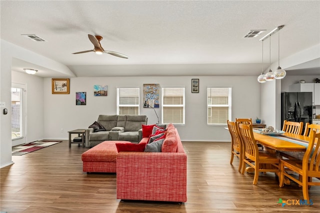 living room with ceiling fan, dark hardwood / wood-style floors, and a healthy amount of sunlight