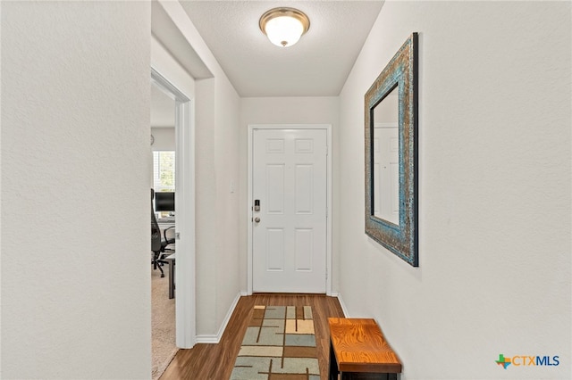 corridor featuring a textured ceiling and dark hardwood / wood-style flooring