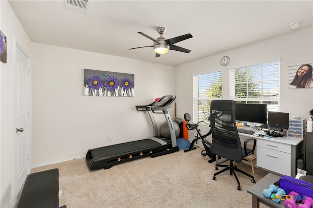 carpeted office space featuring ceiling fan