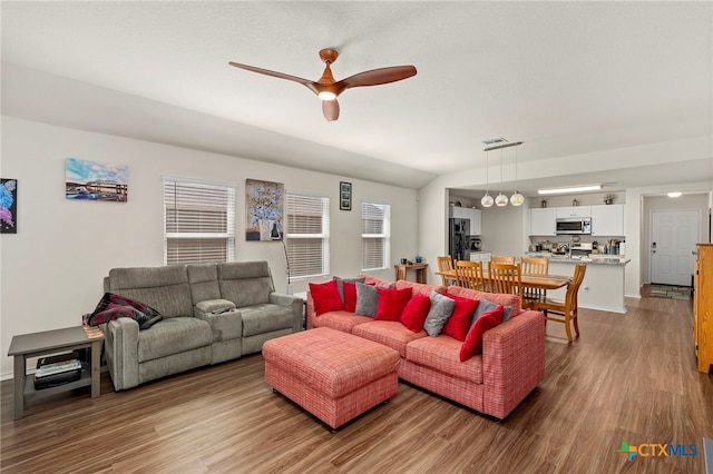 living room featuring vaulted ceiling, hardwood / wood-style flooring, ceiling fan, and plenty of natural light