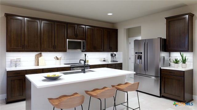 kitchen with dark brown cabinetry, sink, decorative backsplash, a center island with sink, and appliances with stainless steel finishes