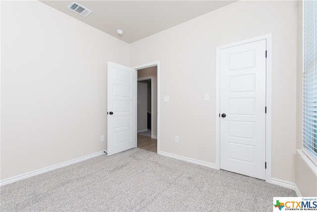 unfurnished bedroom with light colored carpet