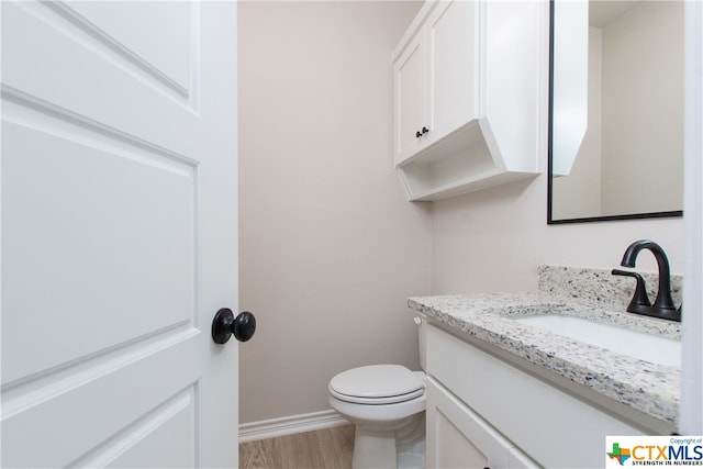 bathroom with vanity, hardwood / wood-style flooring, and toilet