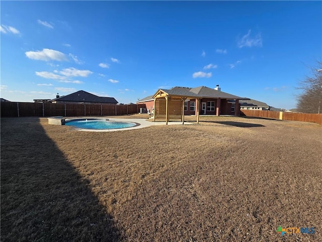 rear view of property featuring a fenced in pool and a patio