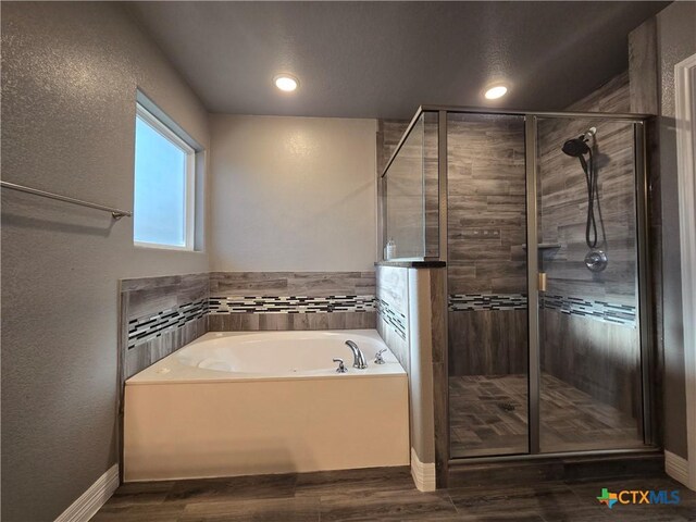 bathroom with shower with separate bathtub and hardwood / wood-style flooring