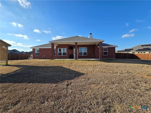 back of property with a lawn and a patio