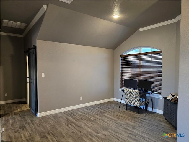 home office featuring a barn door, dark hardwood / wood-style floors, a textured ceiling, vaulted ceiling, and ornamental molding