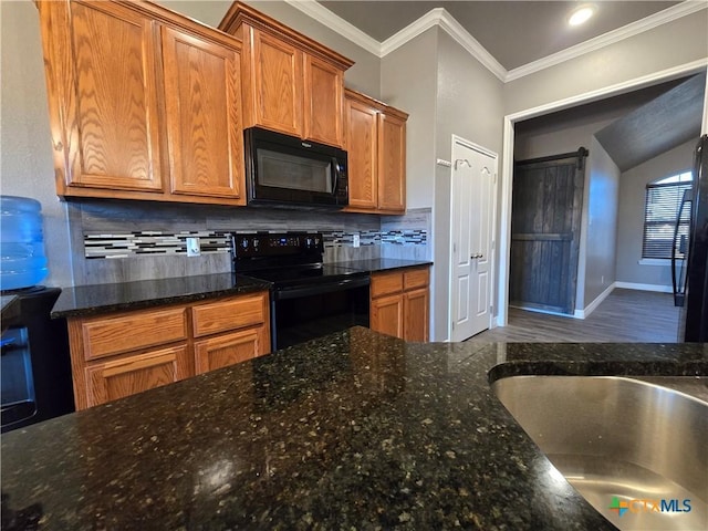 kitchen with black appliances, decorative backsplash, sink, ornamental molding, and dark stone counters