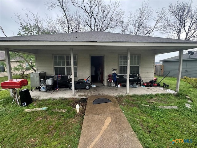 9 S 19th St, Temple, TX 76504 - rear view of property featuring a lawn, a patio area, and a shingled roof