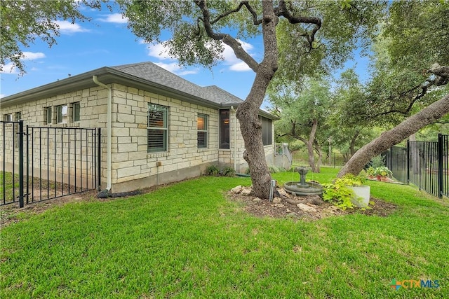 view of home's exterior featuring a fenced backyard, stone siding, a shingled roof, and a lawn