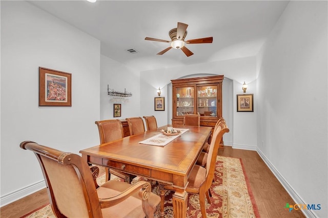dining area with ceiling fan, baseboards, wood finished floors, and visible vents