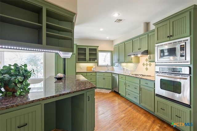 kitchen with dark stone counters, sink, appliances with stainless steel finishes, and green cabinetry