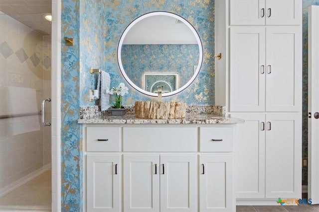 bathroom with tile patterned floors, vanity, and walk in shower