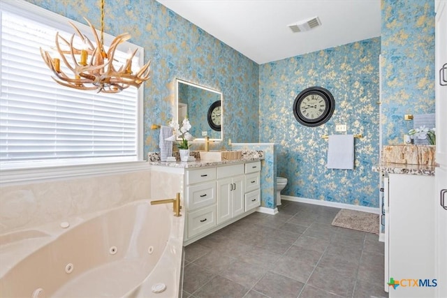 bathroom with a washtub, tile patterned flooring, a notable chandelier, toilet, and vanity