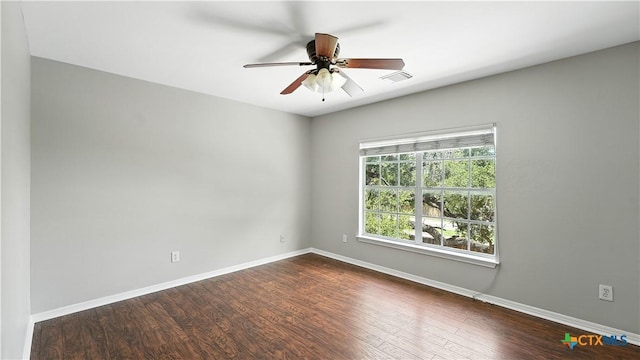spare room with dark wood finished floors and ceiling fan