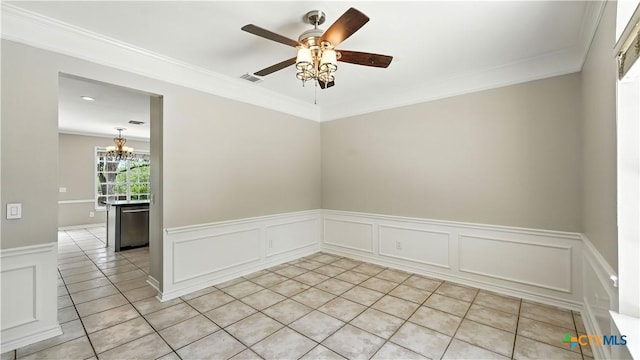 unfurnished room featuring crown molding, a chandelier, wainscoting, a ceiling fan, and light tile patterned flooring