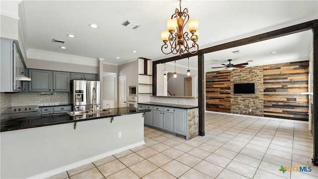 kitchen featuring stainless steel fridge with ice dispenser, dark countertops, gray cabinetry, ceiling fan, and crown molding