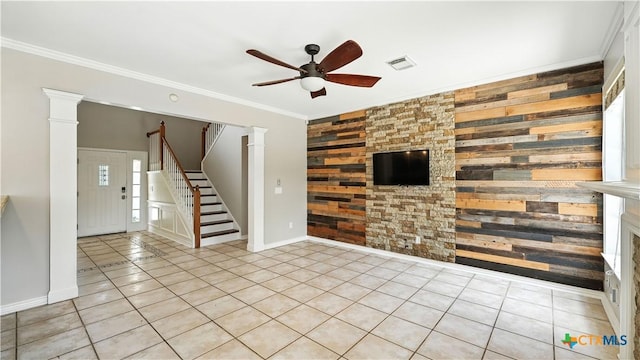 unfurnished living room with a ceiling fan, stairway, wooden walls, tile patterned floors, and crown molding