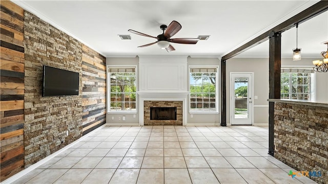 unfurnished living room with ornamental molding, a fireplace, a ceiling fan, light tile patterned floors, and a chandelier