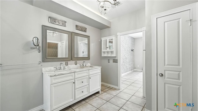 bathroom with double vanity, tile patterned flooring, and a chandelier