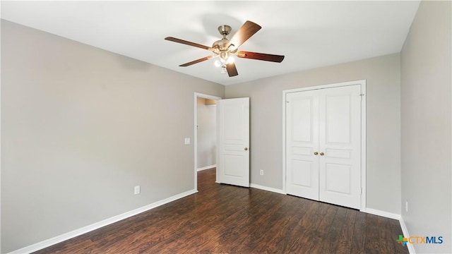 unfurnished bedroom featuring dark wood-type flooring, a closet, and a ceiling fan